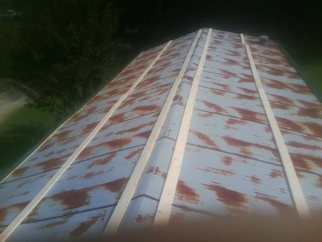 Rusted metal roof panels with new wood purlins before replacement — Storm Damage Roof Repair in Clairton by Roofing Brothers