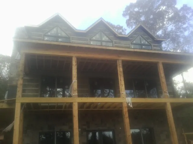 Dormers and porch framing on a large log home under construction — Roof Coating work by our crew in Clairton