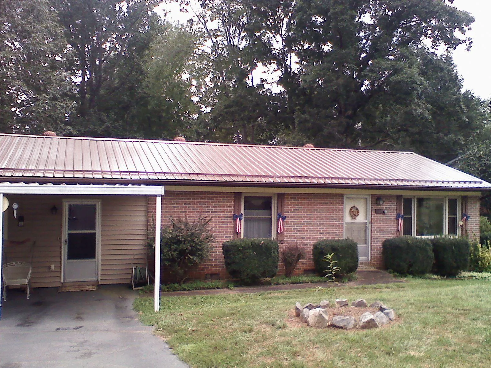 Bronze metal roof and carport on a brick ranch home — Roof Repair work by our crew in Clairton
